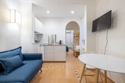 a living room with a blue couch and a table at Elle Cavour Apartment in Rome