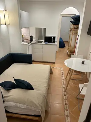 a room with a bed and a table and a kitchen at Elle Cavour Apartment in Rome