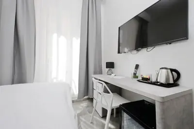 a white room with a desk with a tv on the wall at DolceVitaSuite in Rome
