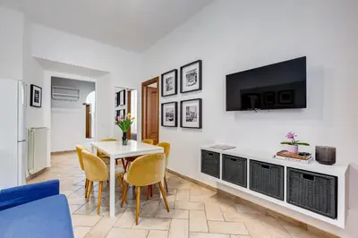 a living room with a table and a tv on a wall at Pantheon Boutique Apartment 