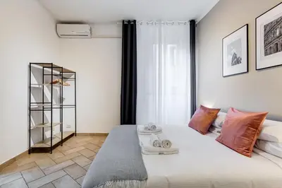 a bedroom with a large white bed with orange pillows at Pantheon Boutique Apartment 