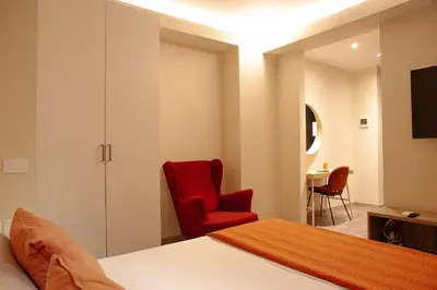 a bedroom with black curtains and a tv at Musa Rooms Roma in Rome