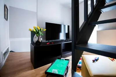 a living room with a television and a table at Piazza di Spagna 66 Luxury Apartment - Maison D'Art Collection in Rome