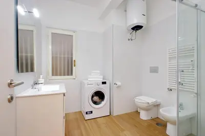 a bathroom with a washing machine and a toilet at suity I cozy segesta apartment in Rome