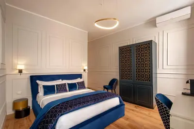a bedroom with a blue bed and a chair at Navona Sky Palace in Rome