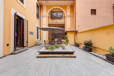 a courtyard with a table and chairs and an umbrella at SPANISH GARDEN in Rome