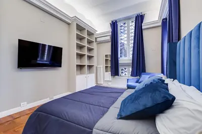 a bedroom with a large bed and a tv at SPANISH GARDEN in Rome