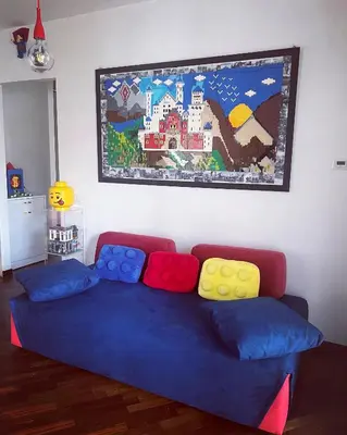 a living room with a blue couch with colorful pillows at Cip's Brickhouse in Rome