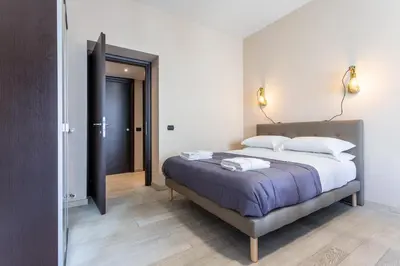 a bedroom with a large bed and a hallway at Naima Apartment San Pietro in Rome