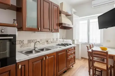 a kitchen with wooden cabinets and a sink at Apartment Nonna Anna in Rome