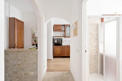 a kitchen with white walls and wooden cabinets at Apartment Nonna Anna in Rome