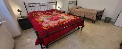a bedroom with a bed with a red and gold blanket at Apartment Nonna Anna in Rome