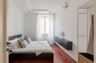 a bedroom with a bed with white walls and a window at iFlat Veneto Area's Penthouse in Rome