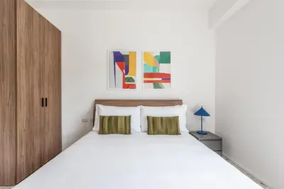 a bedroom with a white bed and a wooden cabinet at Numa Rome Verso in Rome