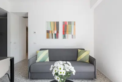 a living room with a couch with flowers on a table at Numa Rome Verso in Rome