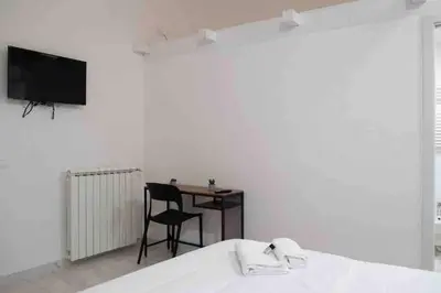 a bedroom with a bed and a table and a television at COLOSSEUM LUXURY HOME in Rome