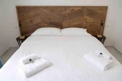 a large white bed with two white towels on it at COLOSSEUM LUXURY HOME in Rome