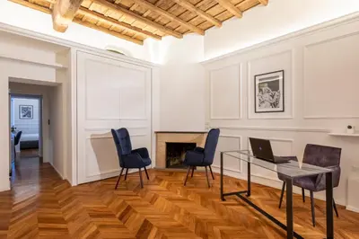 a living room with a table and chairs and a laptop at Largo Arenula Suites in Rome