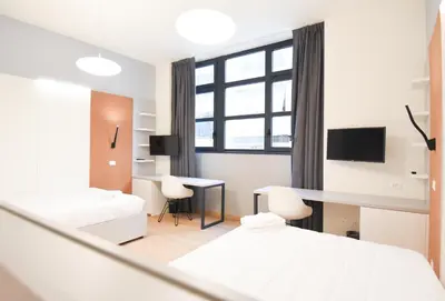 a white room with a bed and a desk at Dotcampus Roma City Center in Rome