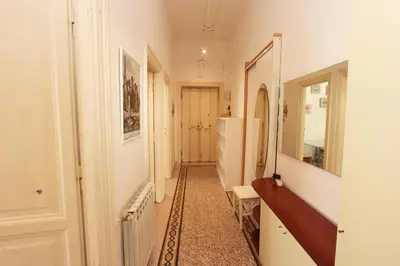 a hallway with white walls and a mirror at Angelo Emo Flat in Rome