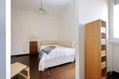 a bedroom with a bed and a dresser and a table at Vatican Charme in Rome