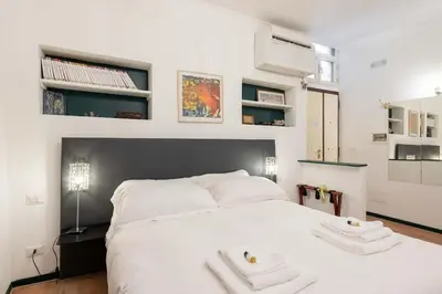 a bedroom with a white bed with two towels on it at Old Trastevere Studio in Rome