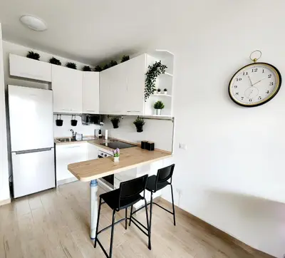 a kitchen with a table and chairs and a clock at Quela Apartment - Pietralata in Rome