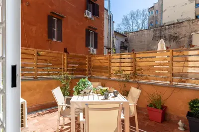 a patio with a table and chairs and a fence at iFlat Shiny Loft in Trastevere in Rome