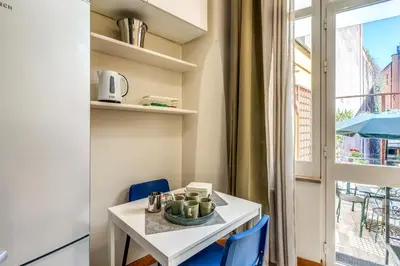 a small white table with blue chairs and a window at Residenza Como in Rome