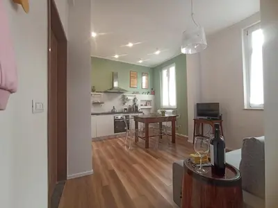 a living room with a table and a kitchen at Casa MANÍ Campo de Fiori in Rome
