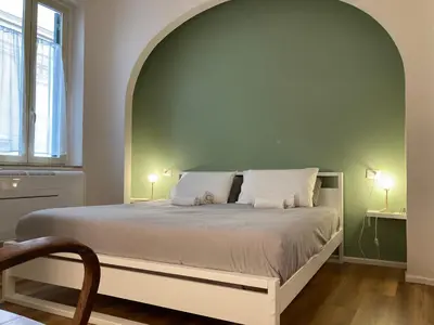 a bedroom with a large bed with an arch above it at Casa MANÍ Campo de Fiori in Rome