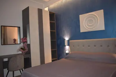 a bedroom with a bed and a desk and a mirror at Gallery House 59 Guest House in Rome