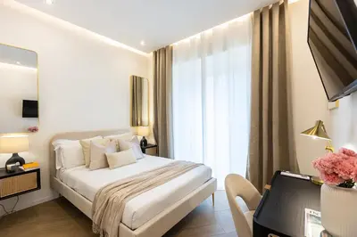 a white bedroom with a bed and a window at Colosseum Boutique Apartment in Rome