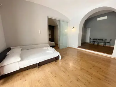 a bedroom with a white bed and a wooden floor at Tolemaide Boutique Apartment in Rome
