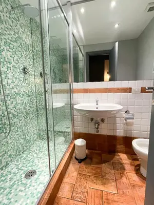 a bathroom with a glass shower and a sink at Tolemaide Boutique Apartment in Rome