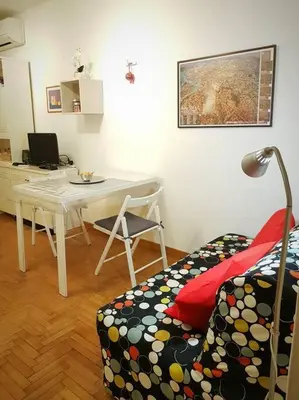 a living room with a table and a chair and a desk at Minohouse Vatican view in Rome