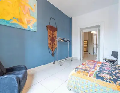 a bedroom with a bed and a blue wall at Casa Benso - near Vatican City and Navona Square in Rome