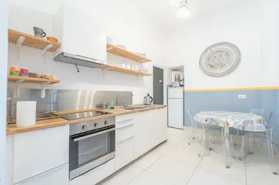 a kitchen with white cabinets and a table at Casa Benso - near Vatican City and Navona Square in Rome