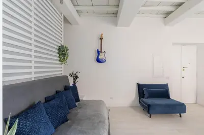 a couch and a chair in a room with a guitar at iFlat The G Flat in Rome