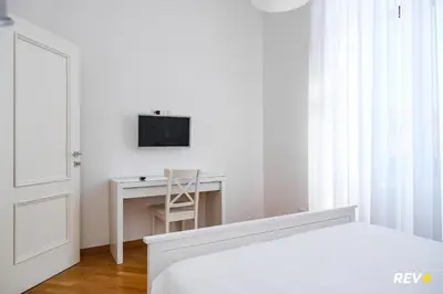 a bedroom with a bed and a desk with a television at Mecenate Apartment Colosseum in Rome