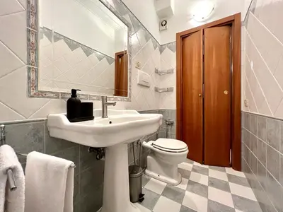 a bathroom with a sink and a toilet and a mirror at Inn Sistina Home in Rome