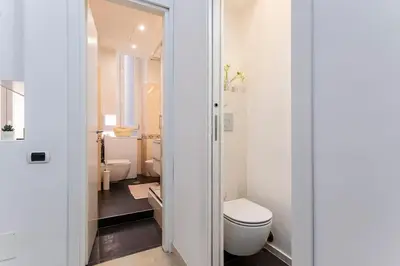 a white bathroom with a toilet and a sink at Holiday Apartment Rome LR Blue in Rome