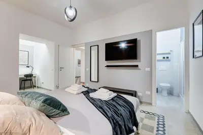 a bedroom with two beds and a tv on the wall at The Great Beauty - 2 double bedrooms & 2 bathrooms in Rome