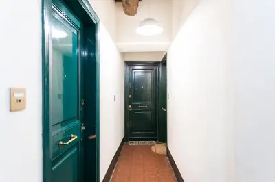 a hallway with two green doors and a brick floor at Lovely Nest by the Pantheon in Rome