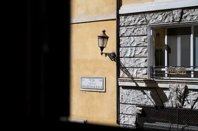 a sign on the side of a building with a street light at Mater Rooms & Suites in Rome