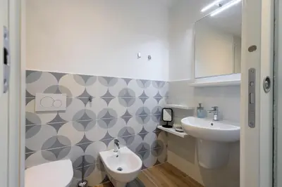 a bathroom with a sink and a toilet and a mirror at Mater Rooms & Suites in Rome