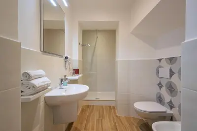 a white bathroom with a sink and a toilet at Mater Rooms & Suites in Rome