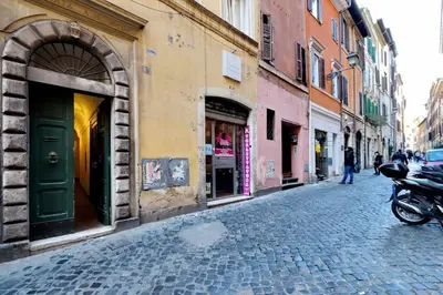 a cobblestone street with buildings and a motorcycle parked on the street at Fontanella Dream apartment in Rome