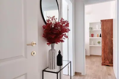 a vase of flowers on a table next to a door at Principe Umberto Apartment in Rome