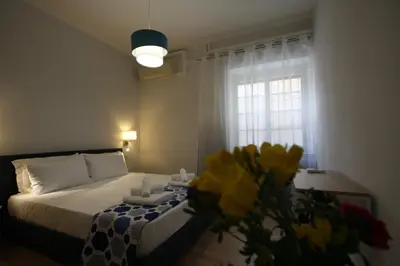 a bedroom with a bed and a vase of flowers at Vascello Holiday House in Rome